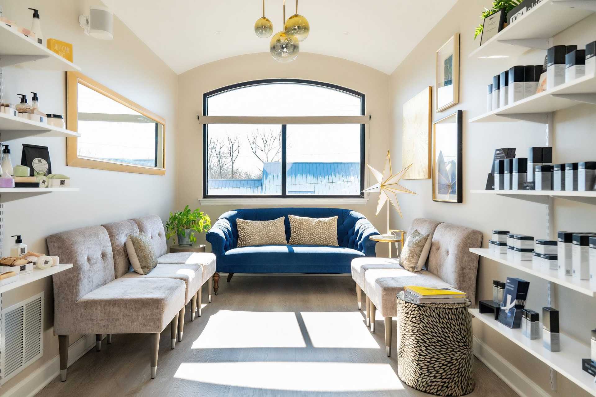 Bright, modern sitting room with a blue sofa at Collective Beauty Med Spa